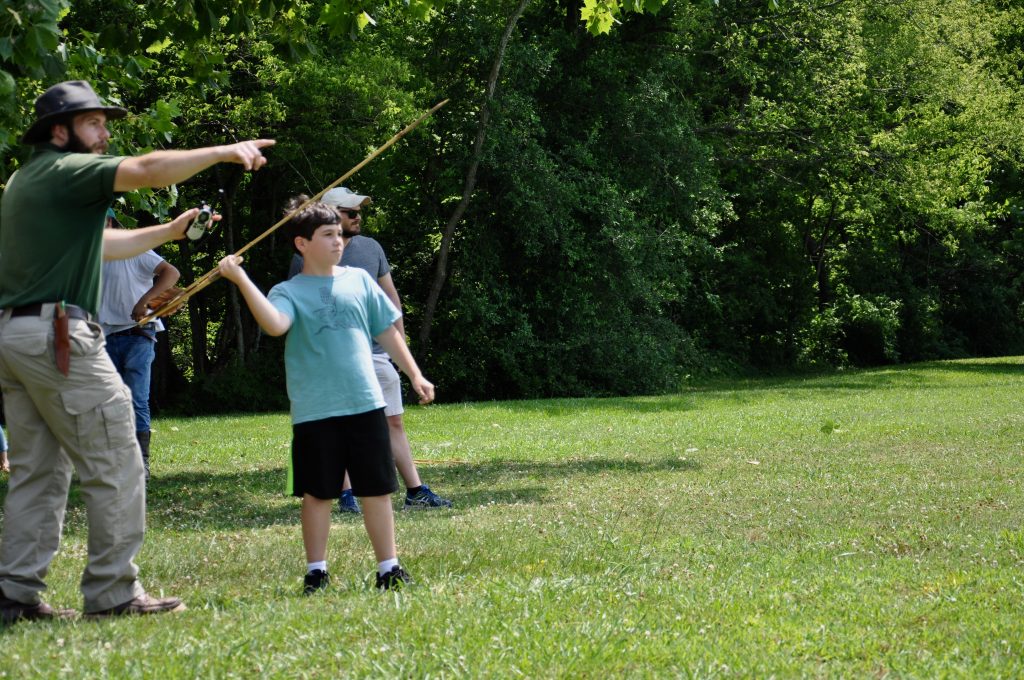 Boy practicing with atlatl.